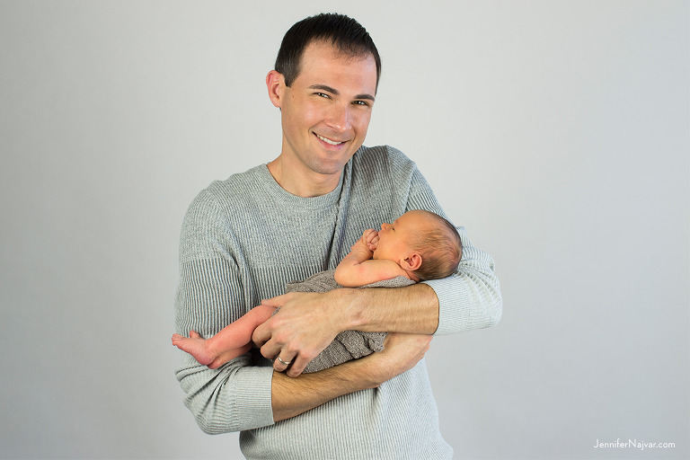 newborn in dad's arms studio portrait