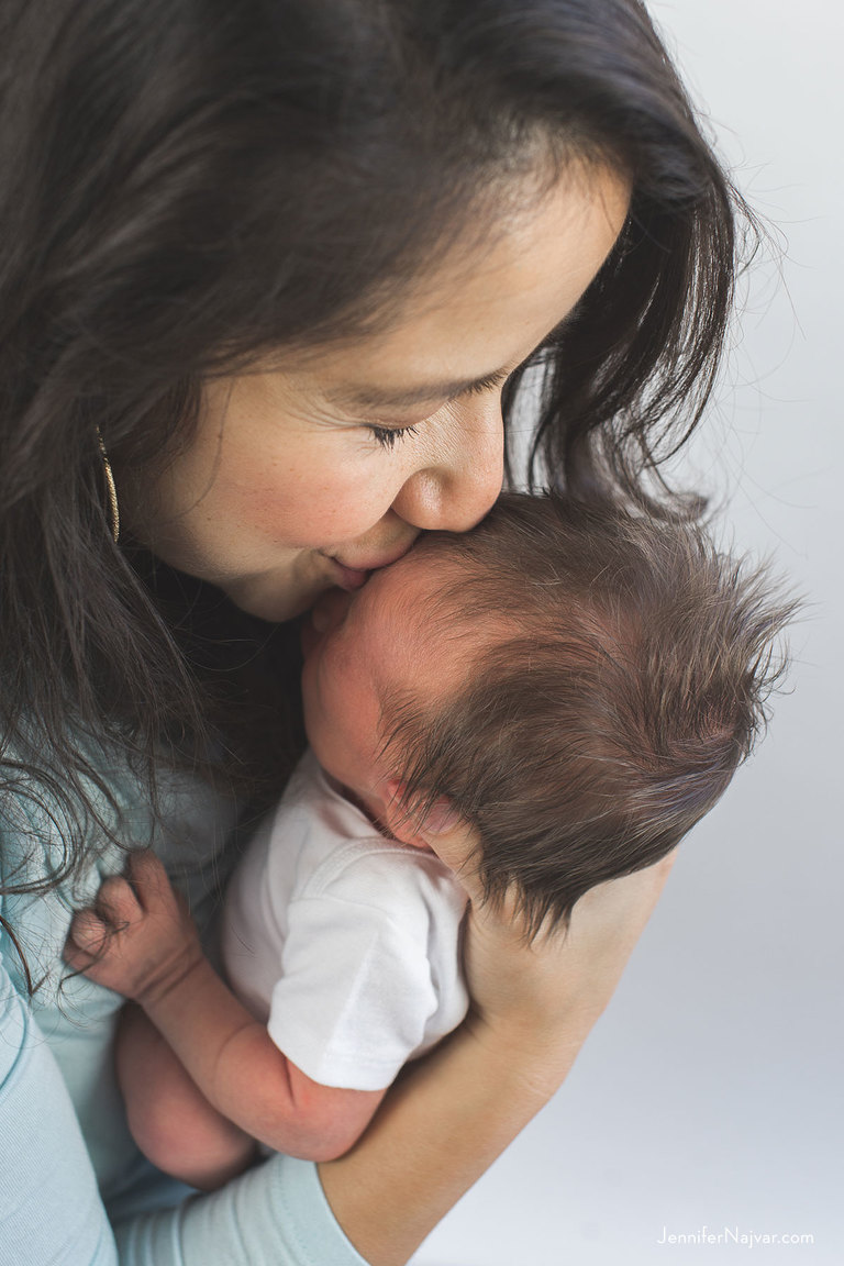 new mother kissing newborn baby